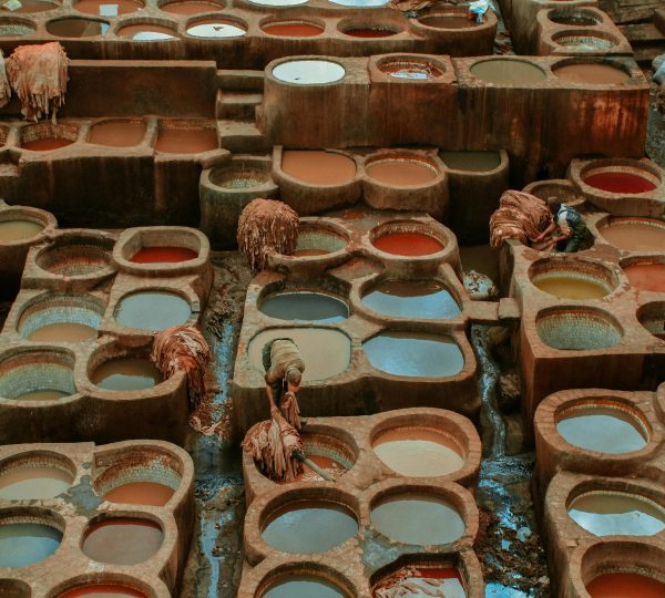 Tans, ateliers de teinture naturelle traditionnels marocains avec bassins colorés dans un souk artisanal.